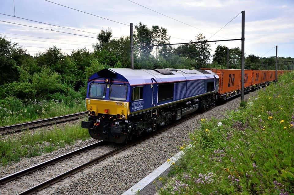 Blauw-gele locomotief met een containertrein