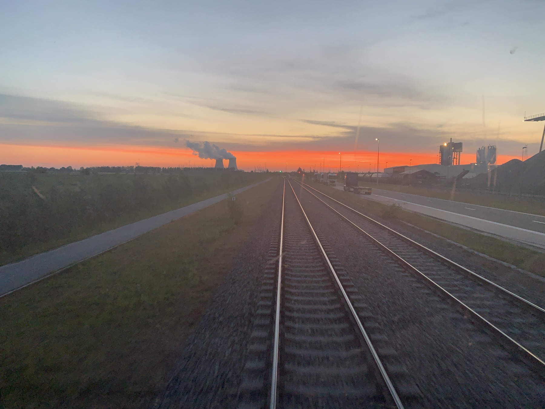 Spoorlijn bij zonsondergang, gezien vanuit de cabine